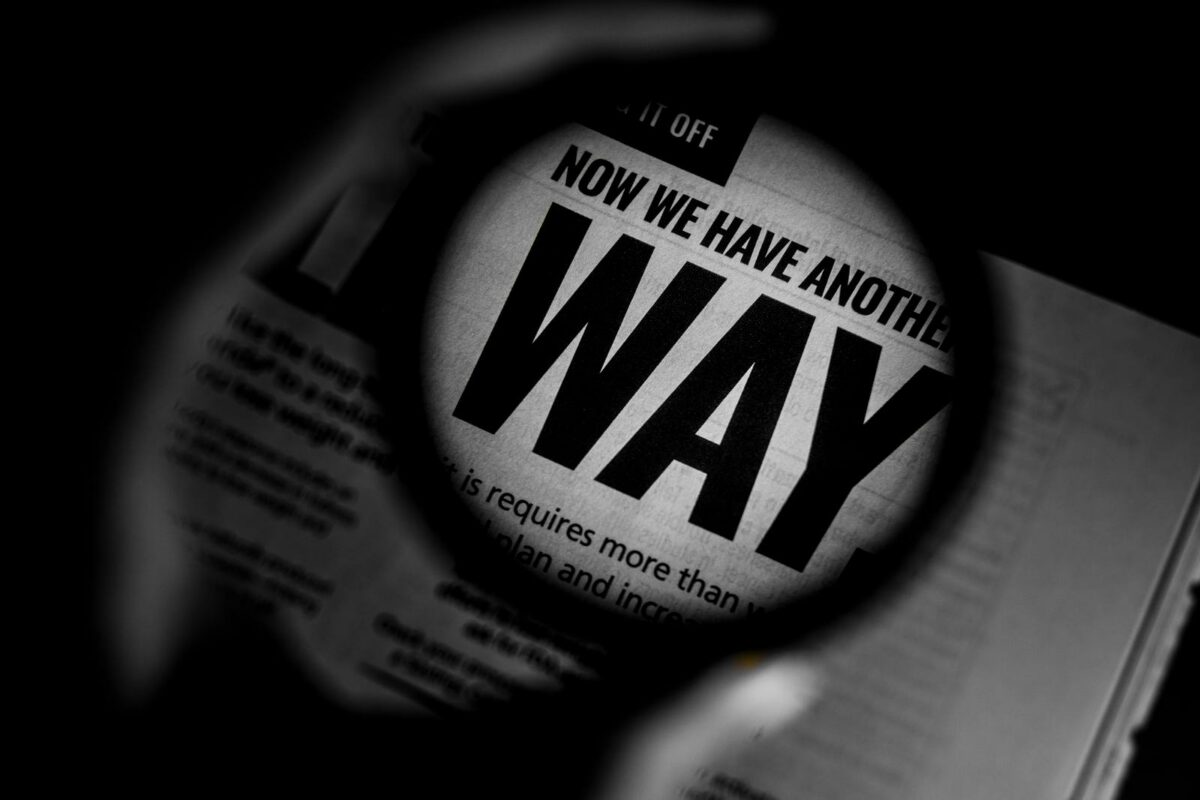 Magnifying glass over a newspaper, representing claim verification.