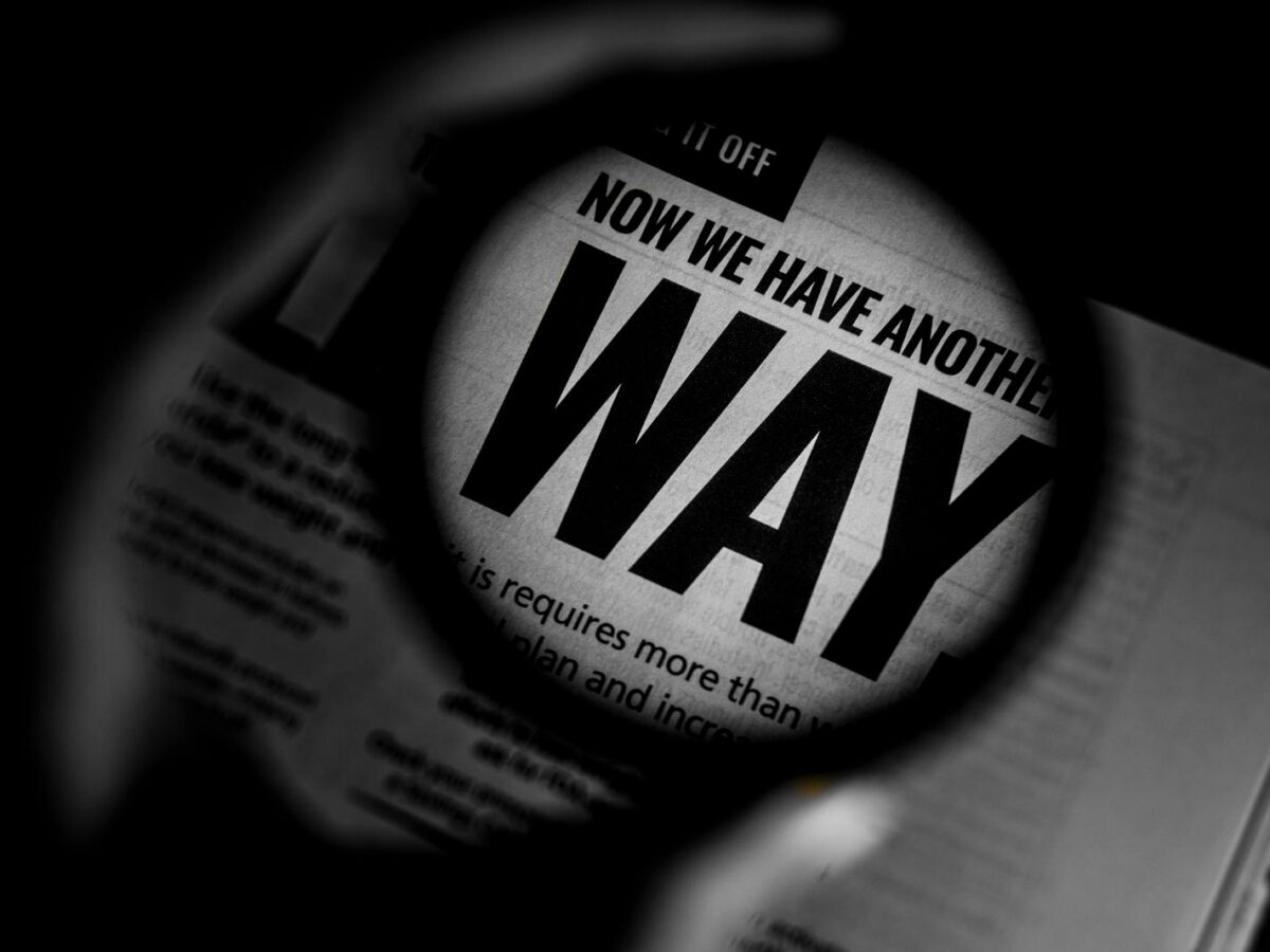 Magnifying glass over a newspaper, representing claim verification.